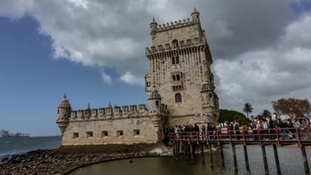Blurred timelapse of Belem tower and tourist row at the riverside of Tejo River