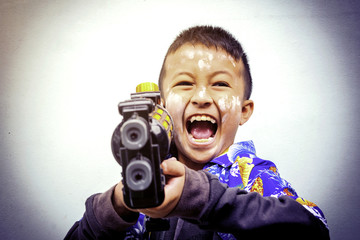 Asian boy wearing a striped shirt  With water gun On Songkran Day