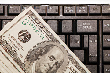 American dollars lie on the laptop keyboard