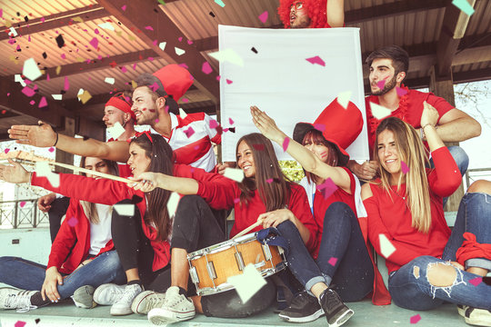 group of fans dressed in red color watching a sports event