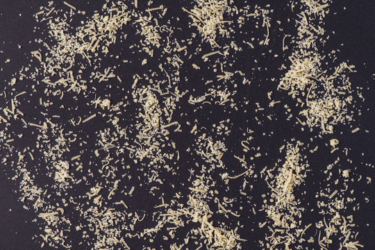 grated parmesan cheese and tomatoes on black background