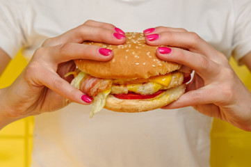 Seafood burger with shrimps holding in young woman hands