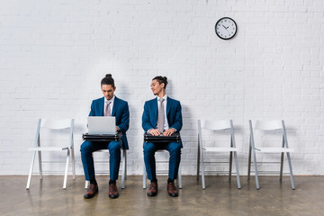 Collage with curious man looking at businessman working on laptop while sitting on chairs