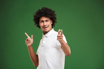 Happy young african curly man pointing.