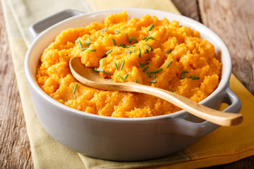 Vegetarian food: mashed sweet potatoes with herbs close-up on a table. horizontal