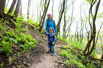 Naklejka premium The boy and his mother are walking through the woods.