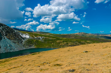 Mountain landscape with clouds. Mountain valley lake. The Altai mountains. Travel adventure vacation background