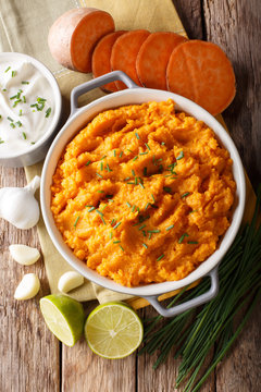 Spicy mashed sweet potato with onion, garlic and lime close-up in a saucepan. Vertical top view