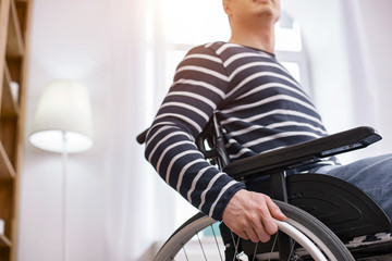 Obraz premium So strong. Handsome man sitting on his wheelchair while being at home