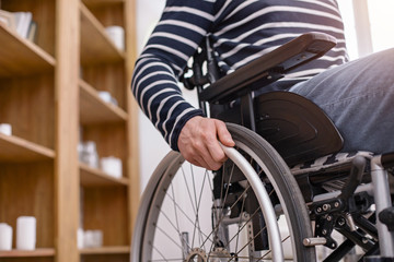 Obraz premium Sposób poruszania się. Niepełnosprawny mężczyzna używający rąk podczas obsługi swojego transportu