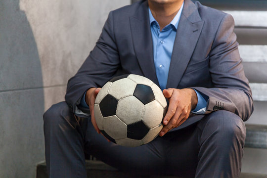man in a suit with a soccer ball