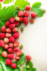 A scattered crop of wild strawberries. Red ripe berry on a light background. Diet Concept Food