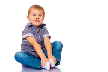 little boy is sitting on the floor