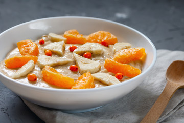 Detox smoothies with flax seed, banana, tangerine, sea buckthorn berries close-up. The concept of a healthy diet