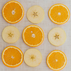 Orange and apple cut into slices, background top view
