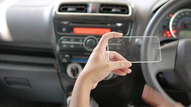 Hands of woman using clear tablet in a car for transport futuristic and technology concept 