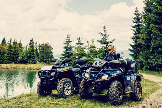 Excited Young Woman On Quad Bike. Happy Young Woman Driving All Terrain Vehicle In Nature.