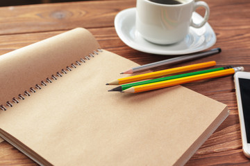 Office desk table top view. Notepad with blank pages on wooden table