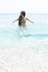 young woman swimming on a beach of clear blue water