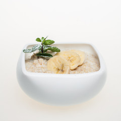 Oatmeal porridge with banana. Oatmeal in bowl, breakfast