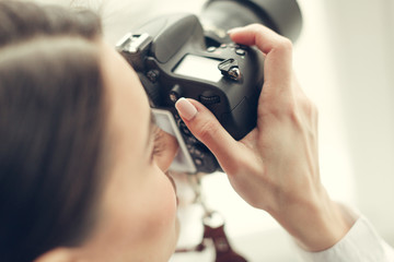 Pretty woman is a professional photographer with dslr camera