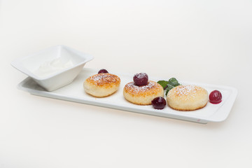 Cottage cheese pancakes with sour cream and cherry berries