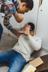 frightened schoolboy being bullied by classmate in school corridor