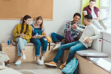 Obraz na płótnie Canvas Multicultural group of high school teenage students reading books during school break