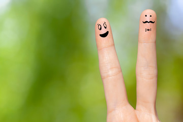 Human hand fingers with funny painted emoticons. People relationships concept