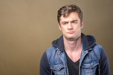 Obraz premium Puzzled thoughtful young man curiously looking at camera