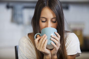 Woman drinking coffee in the morning at kitchen