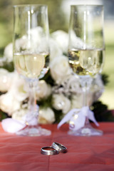 Two golden wedding rings on silk and glasses.