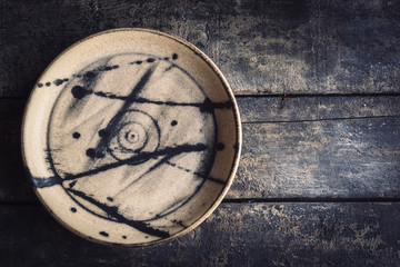Empty ceramic plate on the wooden background with blank space