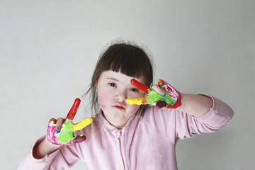 Cute little girl with painted hands. Isolated on grey background.