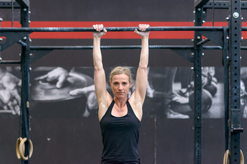 Woman working out on cross bars in a gym