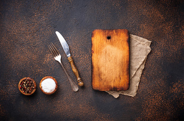 Empty vintage cutting board with spices and cutlery