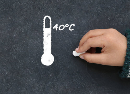 Little boy drawing high temperature on a blackboard