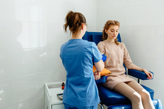 Doctor Makes The Patient An Injection Of A Young Woman. In The Office Of The Doctor Takes A Blood Sample To The Test With The Patient's Arm. Top View