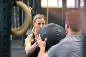 Obraz premium Man and woman working out with a medicine ball