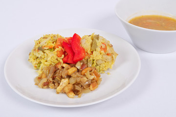 Risotto with vegetables and nuts on a white