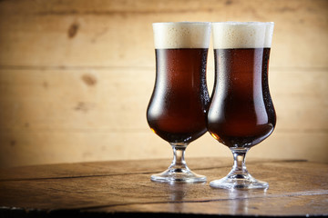 Chalices of brown ale beer with thick foam