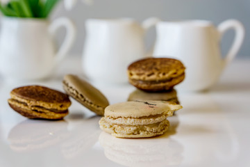 Closeup of french macaroon with a taste of caramel and chocolate on a white table background, shallow depth of focus. Concept Valentine day.