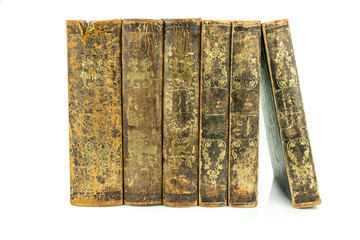 Six aged ancient old leather books standing, studio shot on white.