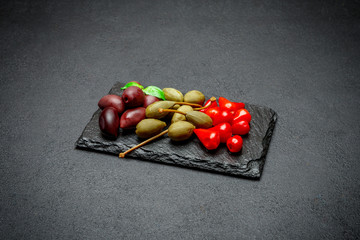Mixed Pickles on stone serving board. Olives, Capers and peppers