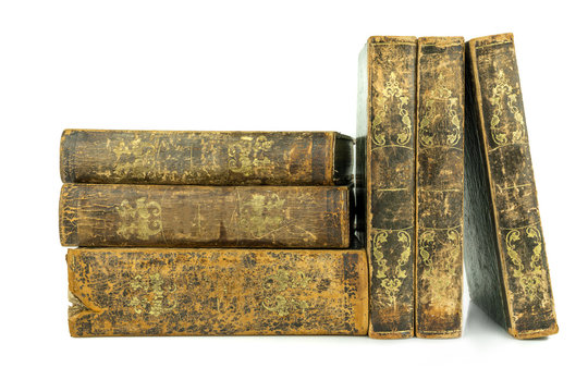 Six aged ancient old leather books stacked and standing, studio shot on white.