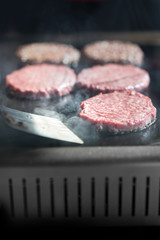 Hamburger cutlet frying on pan.Natural meet loaf pieces cooking in the kitchen.Burger sandwich meat being cooked with a lot of white smoke from a fat and oil.