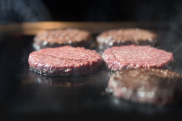Hamburger cutlet frying on pan.Natural meet loaf pieces cooking in the kitchen.Burger sandwich meat being cooked with a lot of white smoke from a fat and oil.