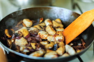 meat is fried in a frying pan with spices