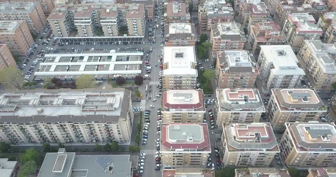 Aerial view on a suburban neighborhood of a large Italian city. There are many buildings in this neighborhood and are crossed by small streets. There are balconies and windows.