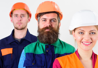 Cheerful team of three constructor workers, men and woman